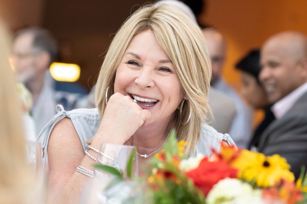 A woman with shoulder-length blond hair smiles