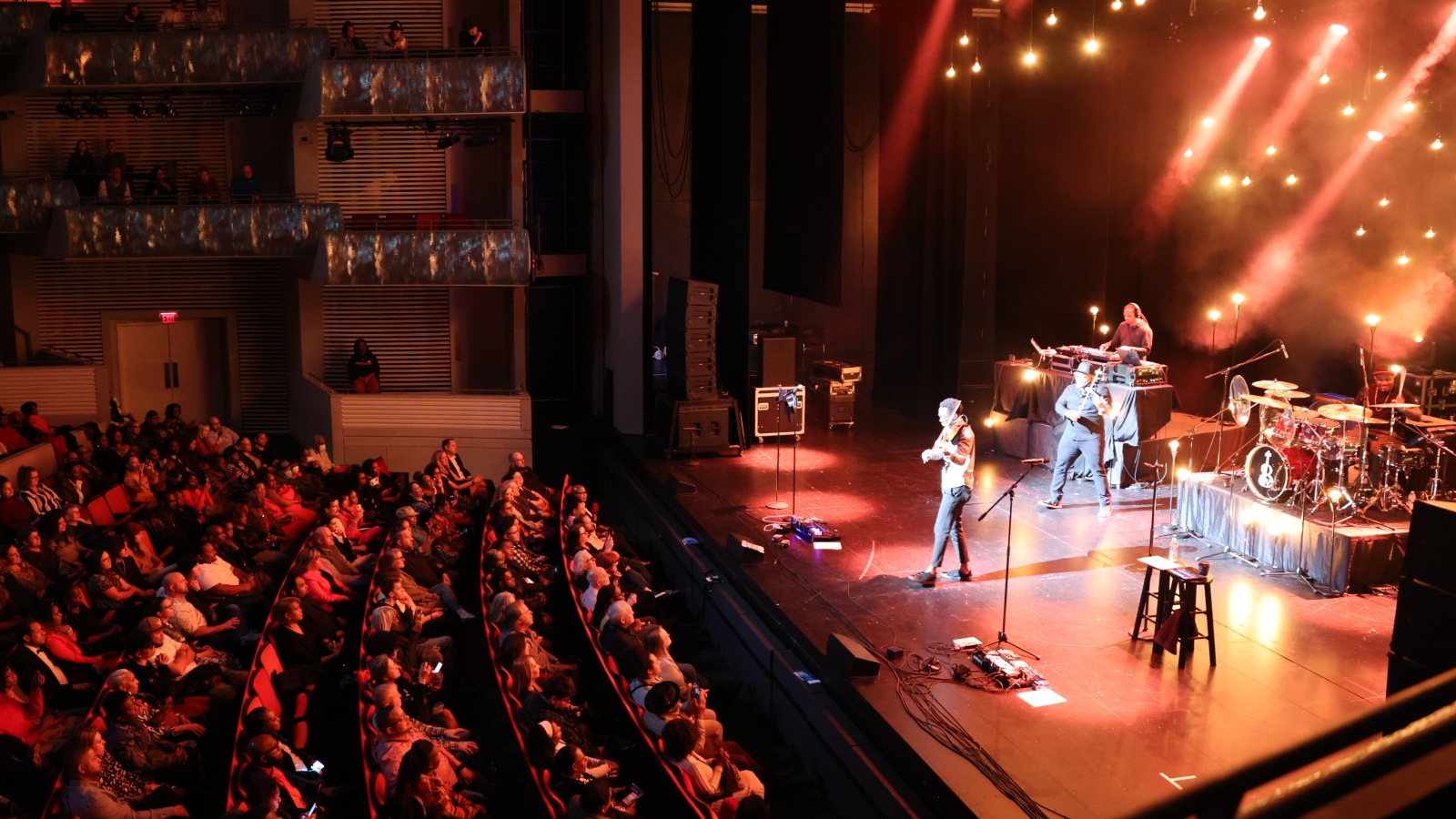 A violinist and violist perform on stage in front of an audience.